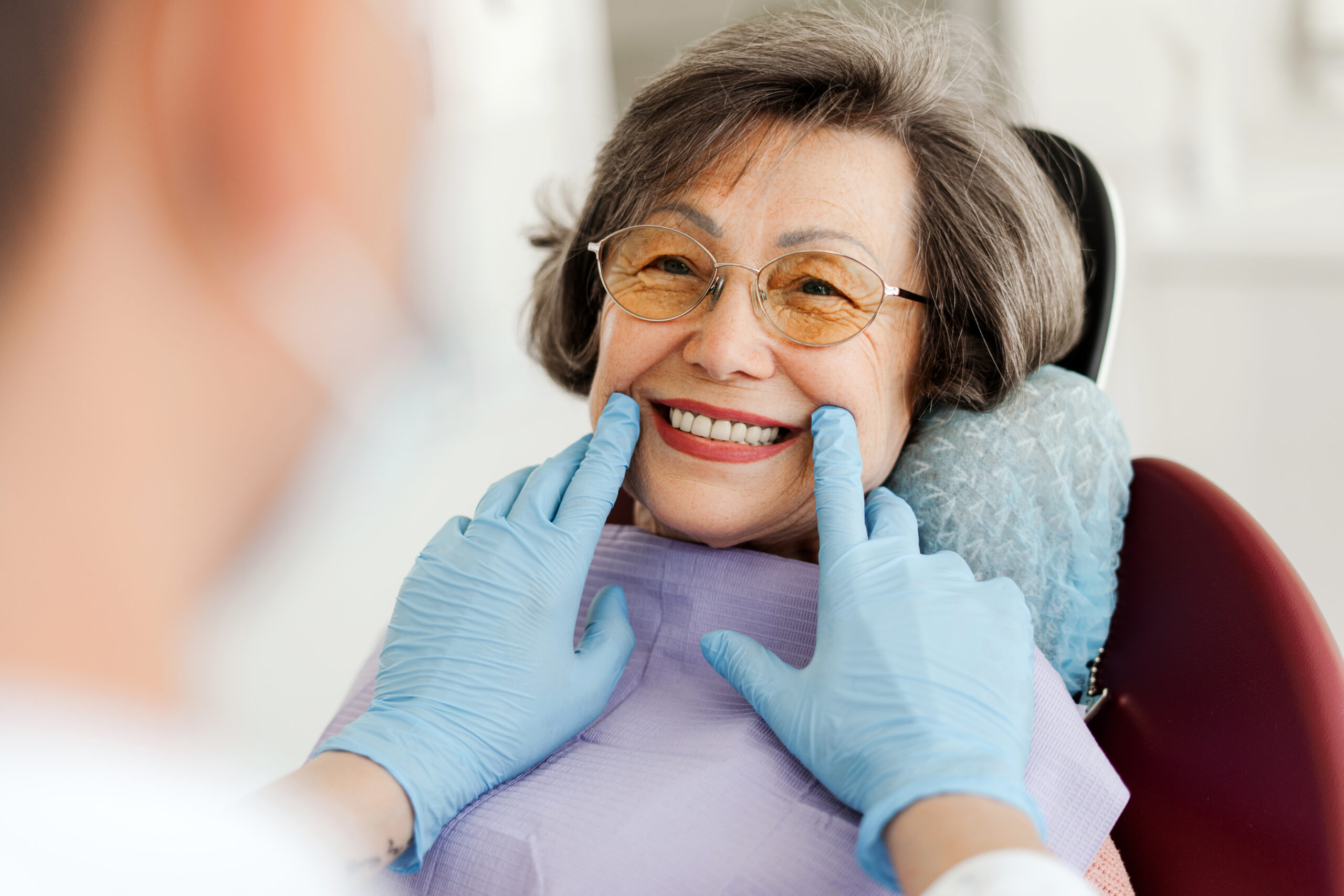 Older woman smiling comfortably during a dental checkup in a family dental office